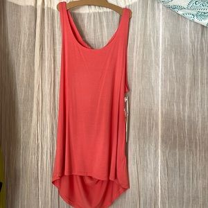 Open back tank.  Higher front neck line.  Length drapes over the tush.